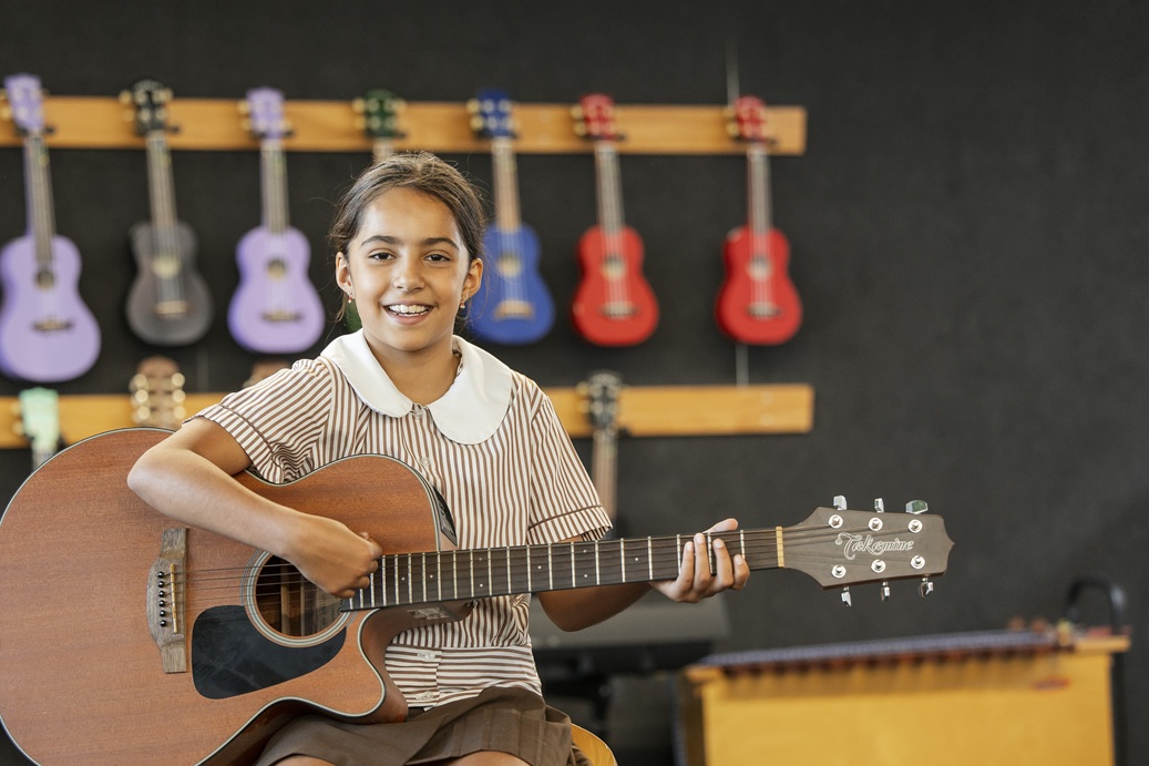 student playing a guitar